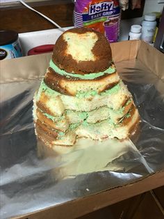 a cake that is sitting on top of some tin foil and has green frosting