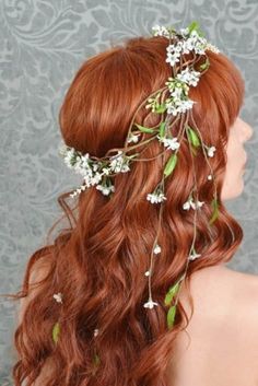 a woman with long red hair and flowers in her hair