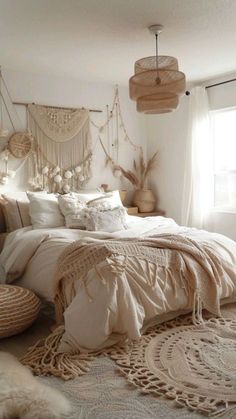 a large bed sitting next to a window in a room with lots of pillows and blankets