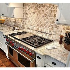 a stove top oven sitting inside of a kitchen next to white cabinets and counter tops