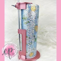 a pink and blue water bottle with the words watch over on it next to a white furnishing