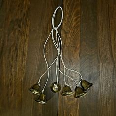 three bells hanging from a string on top of a wooden floor