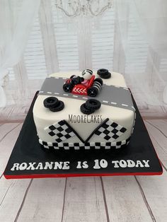 a cake that is shaped like a race car on top of a black and white plate