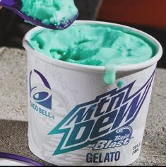 a cup filled with green gelato sitting on top of a counter