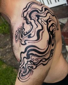 a man with a black and white swirl tattoo on his arm, showing the design