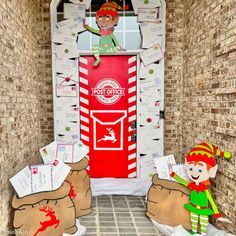 two elfs are standing in front of a door decorated with mail and christmas decorations