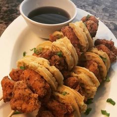 chicken skewers on a plate with dipping sauce