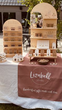 the table is set up with wooden boxes and plates on it for sale in front of an outdoor cafe