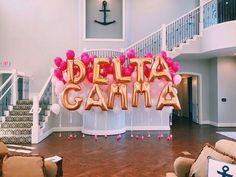 the balloon letters that spell out delta gama are on display in front of a staircase