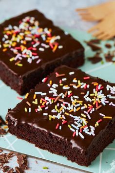 two brownies with chocolate frosting and sprinkles on a blue plate