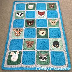 a crocheted blanket with animals on it is sitting on the floor in front of a couch