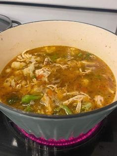 a pot filled with soup sitting on top of a stove