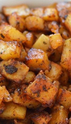 a white bowl filled with cooked potatoes on top of a table