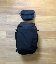 two backpacks sitting on the floor next to each other, one black and one blue