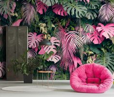 a pink chair sitting in front of a wall with green leaves on it and a lamp next to it