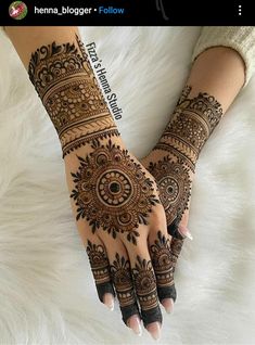 two hands with henna tattoos on them