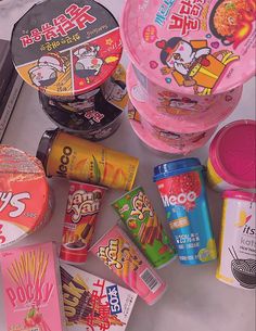 many different types of candy are on the table next to some cans and containers with lids