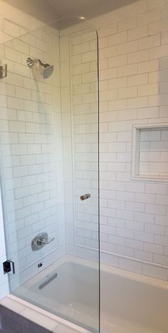 a bath tub sitting under a window next to a shower head mounted faucet