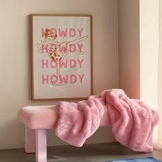 a pink bench sitting in front of a painting on the wall next to a window