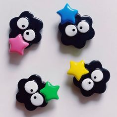 four black and white buttons with different colored stars on each one, all decorated in the same style