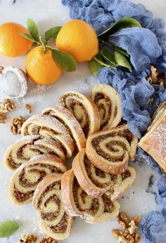 there are many different types of pastries on the table with oranges and nuts