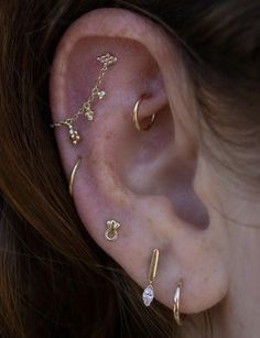 a close up of a person's ear with three different types of piercings