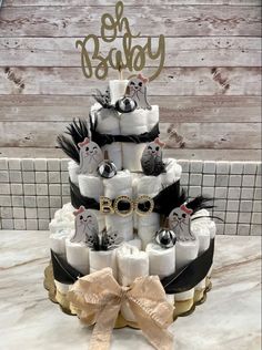 a three tiered diaper cake is decorated with black, white and gold decorations