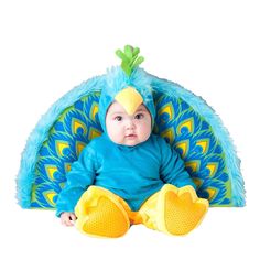 a baby in a blue bird costume sitting on the ground