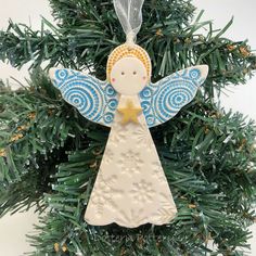 an angel ornament hanging from a christmas tree