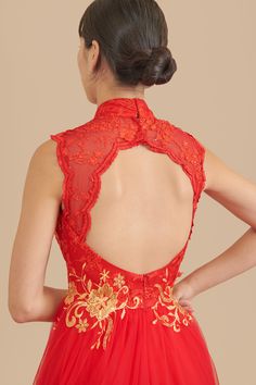 the back of a woman's red dress with gold embroidered flowers and lace detailing