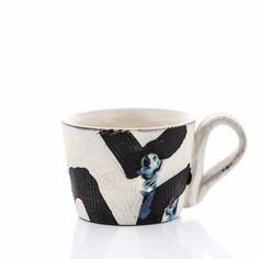 a white and black coffee cup sitting on top of a table