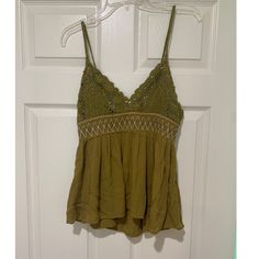 Adorable Army Green Top Never Worn Before!! Like Brand New!! Has A Crochet Top, Stretchy Elastic Band In Middle, And Chiffon Like Flowy Bottom. The Tie In The Back Allows For An Adjustable Strap Length. Open Knit Lace V-neck Top, Lace Open Knit V-neck Top, Lace V-neck Top With Open Knit, Lace V-neck Open Knit Top, Green Lace Camisole Top, Green Sleeveless Crochet Top With Crochet Trim, Green Lace Cami Top, Casual Green Lace Top, Casual Crochet Trim Camisole Top