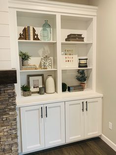 a living room with white bookcases and fireplace