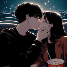 two people kissing each other while eating popcorn