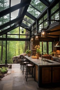 an outdoor kitchen with large windows and lots of counter space in front of the bar