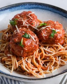 spaghetti and meatballs are served in a bowl