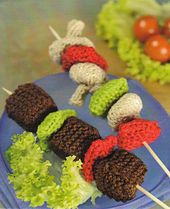 several skewers of food on a blue plate with lettuce and tomatoes