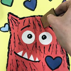 someone is cutting out the heart shaped monster paper for valentine's day art project