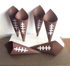 four paper cones with footballs on them