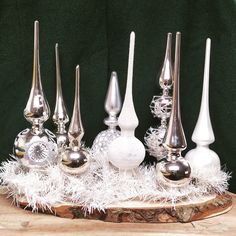 a group of silver and white ornaments sitting on top of a wooden table