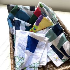 a wicker basket filled with folded towels and cloths on top of a table