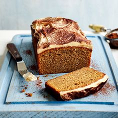 a loaf of bread sitting on top of a cutting board next to a butter knife