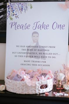 a sign that says please take one next to a basket filled with candies and marshmallows