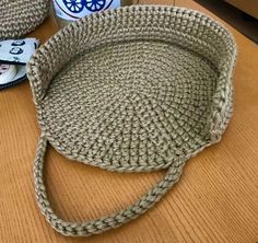 a crocheted basket sitting on top of a wooden table