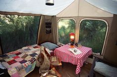 the inside of a tent with a bed and table