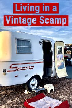 an old camper with the words living in a vintage scamp on it's side