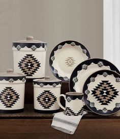 an assortment of black and white dinnerware on a table