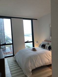 a bedroom with a large window overlooking the city