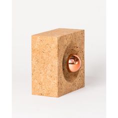 an object made out of cork with a metal ball in it's center on a white background