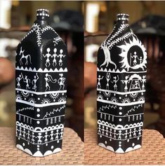 two black and white vases sitting on top of a table